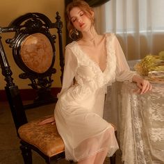 Introducing the Robe du Soir Jeannie, a French-inspired nightgown that exudes elegance and vintage charm. Slip into this luxurious piece and indulge in a taste of luxury, reminiscent of a bygone era. Let the intricate details and French style transport you to a world of sophistication and refinement. Truly a must-have for any discerning individual. Elegant V-neck Evening Nightgown, Elegant Evening Nightgown With V-neck, Elegant V-neck Vintage Wedding Dress, Elegant Long Sleeve Sleepwear, Elegant Sheer Night Dresses, Elegant Sheer Dresses For Night, Feminine Evening Gown With Lace Trim, Elegant Long Sleeve Sleepwear For Wedding Night, Elegant Long Sleeve Lace Nightgown