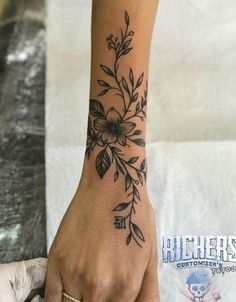 a woman's hand with a flower tattoo on it