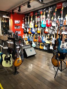 guitars and amps are on display in the music store's guitar room,