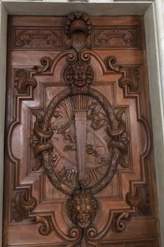 an ornate wooden door with a clock on it