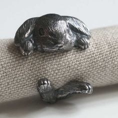 a close up of two small metal animals on a piece of cloth with their eyes closed