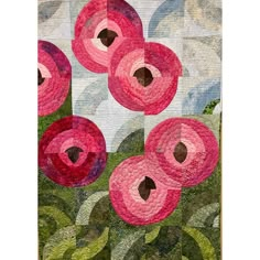 a quilted wall hanging with pink flowers on it