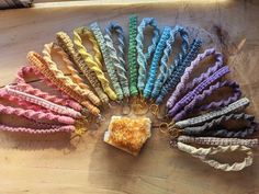 a bunch of different colored hair ties on a wooden table with a piece of cake in the middle