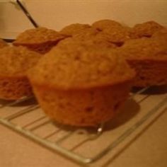 three muffins cooling on a wire rack in the middle of a counter top