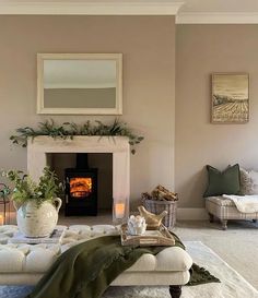 a living room filled with furniture and a fire place next to a fireplace covered in greenery