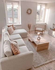 a living room filled with white furniture and lots of natural light coming through the windows