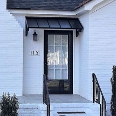 the front door of a white house with black trim