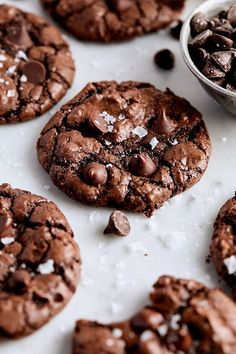 several chocolate cookies with sea salt on top and one cookie in the middle next to it