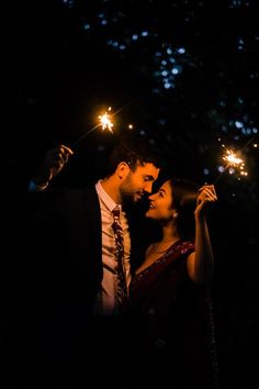 a man and woman holding sparklers in their hands