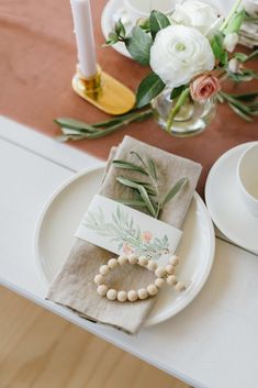 the table is set with white flowers and napkins