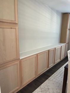 an empty room with wooden cabinets and white carpet