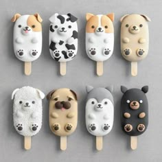 six pops with dogs and cats on them are lined up against a gray background,