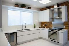 a kitchen with white cabinets and stainless steel appliances