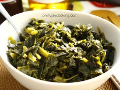 a white bowl filled with greens on top of a table