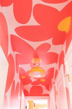 the hallway is painted in bright pink and orange colors with an abstract flower pattern on the ceiling