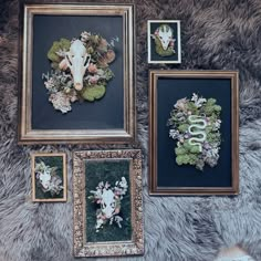 four framed pictures with flowers and animals on them, all hanging up against a wall