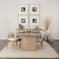 a dining room table with chairs and pictures on the wall above it, in front of a rug