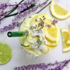 a drink with lemon slices and lavender flowers