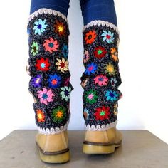 the legs of a woman wearing colorful crocheted boots