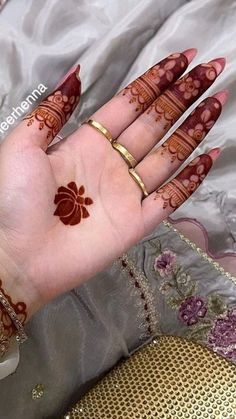 a woman's hand with henna tattoos on it