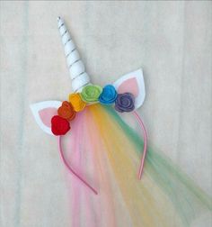 a rainbow colored unicorn's head with flowers on it and a long horn for the mane