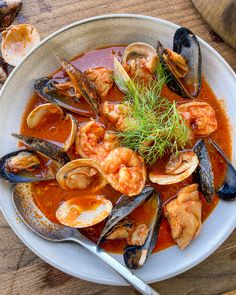 a pan filled with seafood and mussels on top of a table