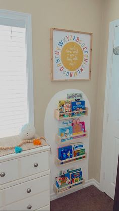 a baby's nursery room with bookshelf and toys