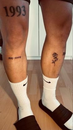 two people with tattoos on their legs and one has a rose tattooed on his leg