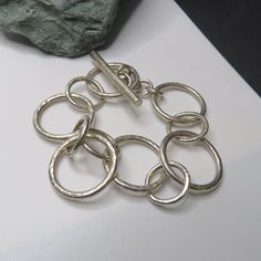 This sterling bracelet measures about 6 3/4 inches around the inside when closed. The largest circles are 24 mm wide. The toggle is over 1 1/2 inches long.  36.8 grams sterling silver chain bracelet, marked 925, vintage, toggle. It is marked 925, but I also used acid testing to determine that it is sterling silver. See pictures of the test. It turned a bright red which indicates sterling. Nickel would have turned dark green or black. Guaranteed sterling. PLEASE CHECK THAT IT WILL FIT BEFORE ORDERING.  Thank you.   For more sterling jewelry from MontanaPrairie, follow this link to my Etsy shop.  MontanaPrairie.etsy.com  All my jewelry is pre-owned, vintage or antique and MAY SHOW NORMAL WEAR, possibly light scratches and slight dings.  It may (and probably will) need a little polishing to r Tarnish Remover, Sterling Bracelets, Sterling Jewelry, Silver Chain Bracelet, Sterling Silver Chain, Chain Link Bracelet, Bright Red, Sterling Silver Chains, Chain Bracelet