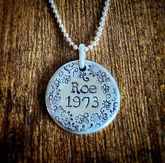 "Show your support for reproductive rights with this custom \"Roe 1973\" necklace! This beautiful pendant is hand stamped with the iconic \"Roe 1973\" slogan and a delicate floral design, making it a truly unique and eye-catching piece of jewelry. Crafted from solid pewter, this thick (3mm) round-ish pendant measures approximately 7/8\" wide, and comes with a shiny silver plated 1.5mm ball chain that measures 16 inches. It features a lobster clasp for easy opening and secure closure, ensuring that your necklace stays securely in place. Perfect for wearing to your next march or rally, this custom pro-choice design necklace is a beautiful and powerful way to show your support for reproductive rights. And because each pendant is hand stamped, every necklace is a bit different, making it a tru Women Right, Bodily Autonomy, Ideas Jewelry, Muslin Bags, Boulder Co, Reproductive Rights, Necklace Flower, Baby Jewelry, Bespoke Jewellery