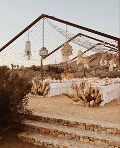 an outdoor dining area with tables and chairs set up for a wedding reception in the desert