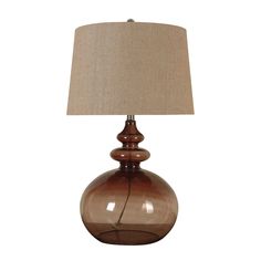 a brown glass lamp with a beige shade on the base and a tan linen lampshade