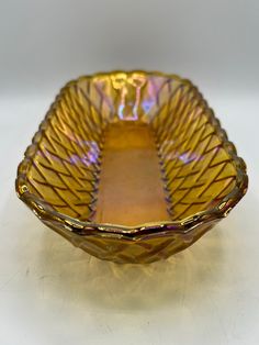 a yellow glass bowl sitting on top of a table