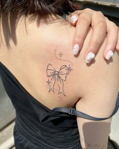 a woman with a bow tattoo on her back