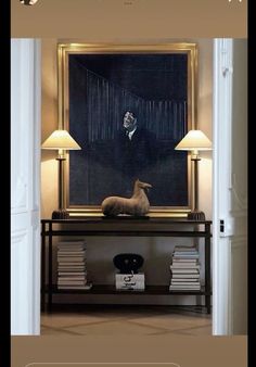 a dog sitting on top of a table in front of a black and gold painting