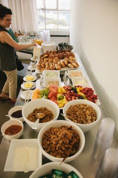 a woman standing in front of a buffet table filled with food