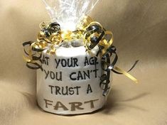 a white toilet covered in black and gold ribbon with words on it that says, at your age you can't trust a fart