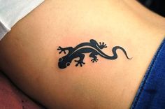 a small lizard tattoo on the stomach