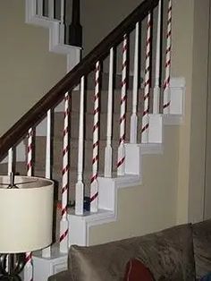 a lamp on a table next to a stair case in a living room with a couch