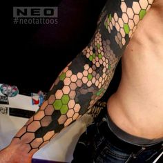 a man with a tattoo on his arm that has hexagons all over it