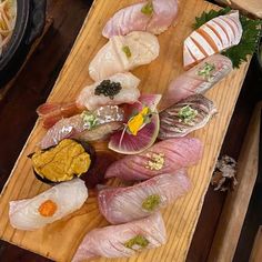 an assortment of sushi on a wooden platter