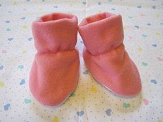 a pair of pink slippers sitting on top of a white table next to a polka dot blanket