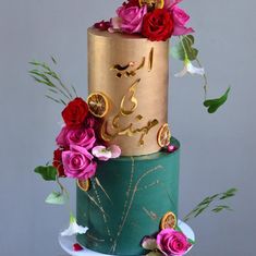 a three tiered cake decorated with gold and pink flowers