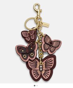 a keychain with two butterflies on the front and one in the back, hanging from