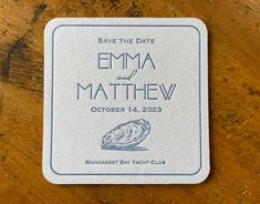 a save the date card on top of a wooden table with an image of a wave