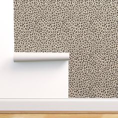 an animal print wallpaper in a room with white walls and wood flooring, along with a rolled up roll of toilet paper