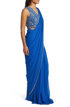 This saree has a hand-embroidered cropped blouse with intricate beadwork and lustrous sequins and is paired with a skirt featuring attached wraparound draping. This outfit is prestitched, so you can put it together in 30 seconds or less. 16" top length; 46" skirt length (size Medium) V-neck Top has hook-and-eye closure; skirt has hidden side-zip closure Blouse and skirt feature hook-and-eye attachments for easy drape adjustments 100% nylon Spot clean Made in India Asian Owned/Founded Drape Saree, Cropped Blouse, A Skirt, Crop Blouse, V Neck Blouse, Fabric Gifts, Free Fabric, 30 Seconds, V Neck Tops