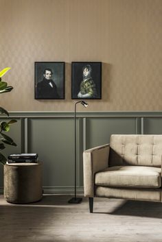 a living room with two paintings on the wall and a couch in front of it