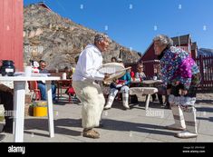 two elderly people playing frisbee in the street - stock image