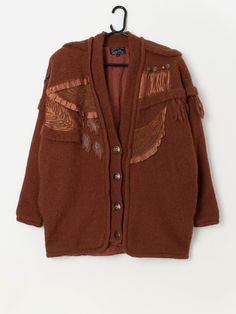 Vintage rust brown cardigan coat with appliqué leaf design and fringed shoulders. This amazing 80s cardigan coat in rust brown features a leaf appliqué design, fringe detail on the shoulders and stud and bead detailing. This cardigan coat also features a deep V-neck a button closure and is fully lined. Made from a heavyweight wool blend with a synthetic lining. A perfect autumn piece!  Our recommended size: XL Label says: Medium Condition: Very good. One bead is slightly loose.  Please see last Vintage Brown Cardigan For Fall, Fringed Wool Outerwear For Fall, Wool Fringe Outerwear For Fall, Fall Wool Outerwear With Fringe, Bohemian Brown Sweater Coat For Fall, Vintage Brown Wool Cardigan, Vintage Brown Cardigan For Winter, Vintage Brown Winter Cardigan, Bohemian Brown Long Sleeve Sweater Coat